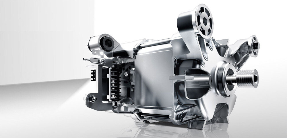 Obraz przedstawia metalowy mechanizm złożony z różnych elementów, takich jak koła zębate i wałki. Tło jest jasne i jednolite, co podkreśla szczegóły konstrukcji.