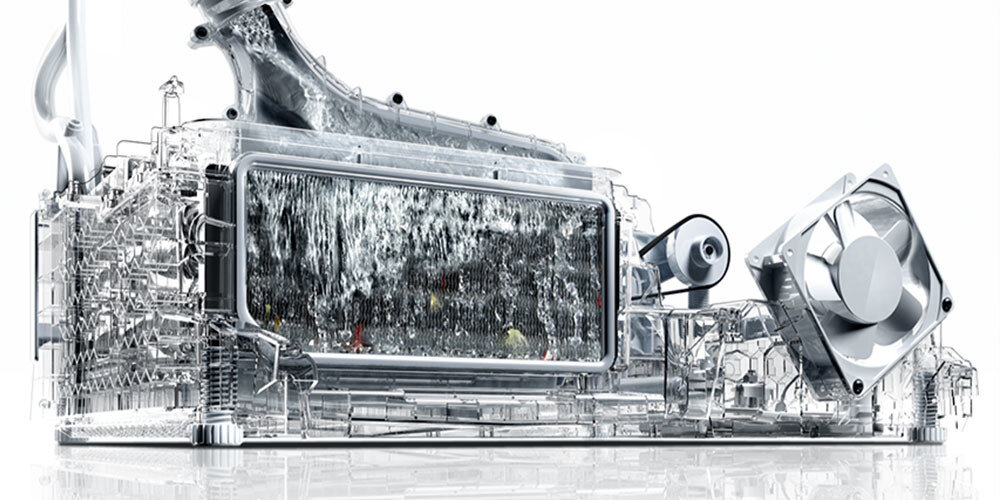 Obraz przedstawia przezroczysty model mechanizmu z widocznymi elementami wewnętrznymi, w tym wentylatorem i rurkami. W centralnej części znajduje się prostokątny element z wodą przepływającą przez niego.