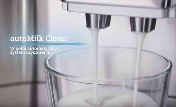 Na obrazie widoczny jest ekspres do kawy, z którego dwóch dysz leje się mleko do szklanki. Obok znajduje się tekst: \'autoMilk Clean W pełni automatyczny system czyszczenia.\'