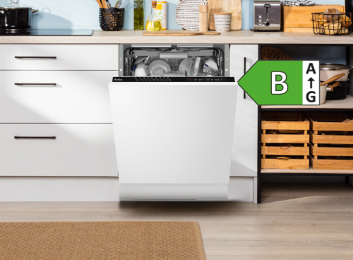 Zmywarka w zabudowie kuchennej z otwartymi drzwiami, widoczne wnętrze z naczyniami. Obok znajduje się etykieta energetyczna z klasą B.