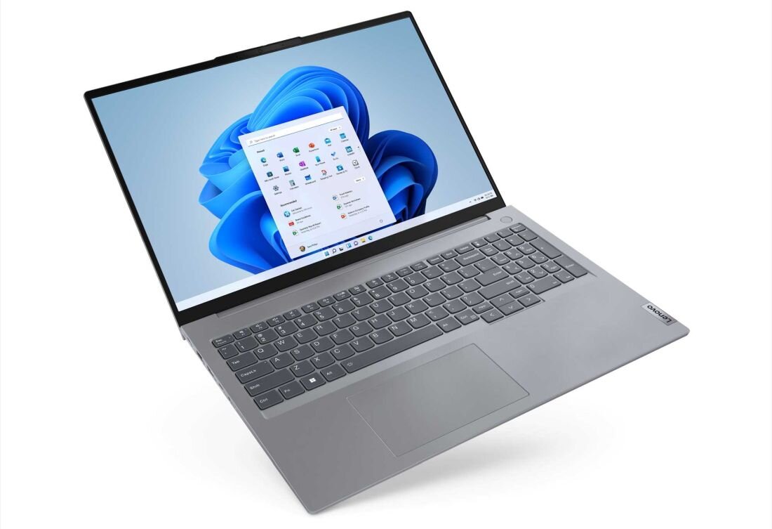 Laptop z dużym ekranem wyświetlającym interfejs systemu Windows 11. Klawiatura jest pełnowymiarowa, a obudowa ma srebrny kolor.