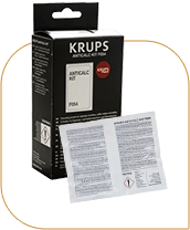 Na obrazie widoczny jest zestaw odkamieniający KRUPS w czarnym opakowaniu z białym tekstem. Obok opakowania znajduje się ulotka z drobnym tekstem.