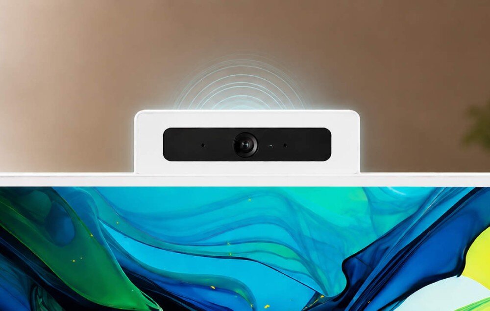 Komputer All in One ACER Aspire C27A-GRPL Zbliżenie na wbudowaną kamerę internetową wysuniętą nad górną krawędź ekranu, z rozchodzącymi się falami dźwiękowymi nad nią