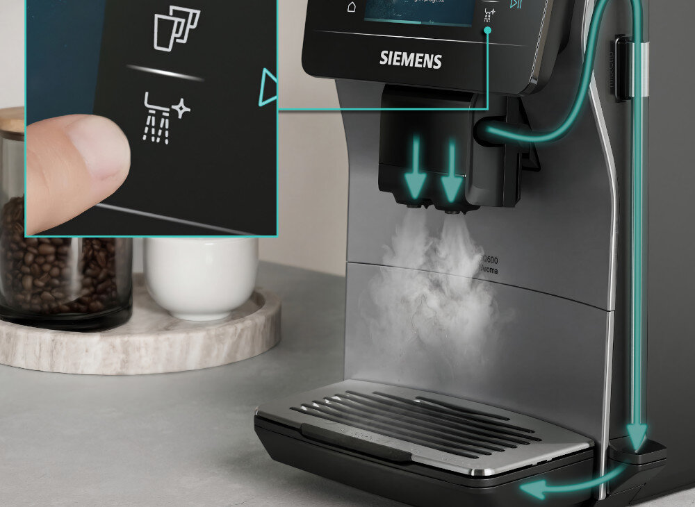 Ekspres do kawy z logo SIEMENS, z wyświetlaczem dotykowym pokazującym ikonę filiżanki i pary. W tle widoczne są ziarna kawy w szklanym pojemniku i filiżanka na podstawce.