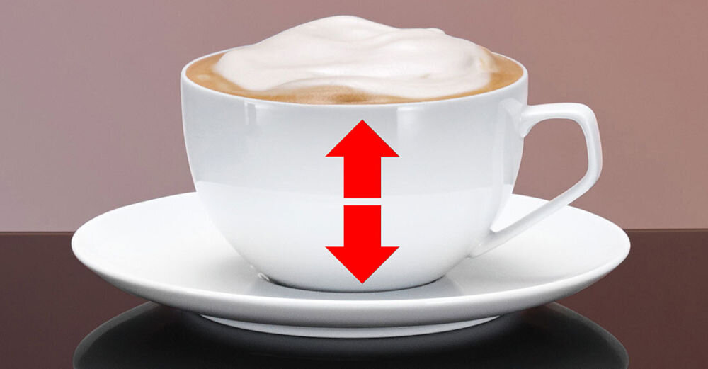 Biała filiżanka z kawą i pianką na spodku, z czerwoną strzałką skierowaną w górę i w dół na jej powierzchni.