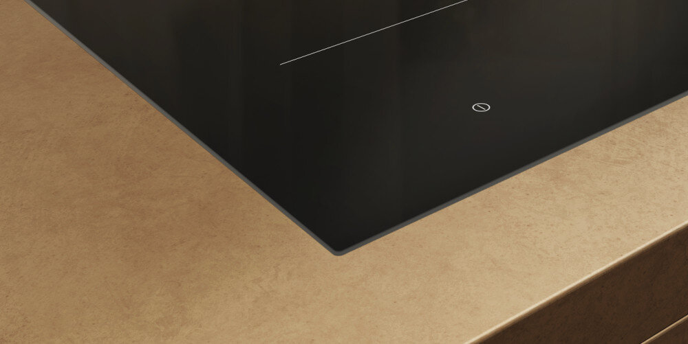 PŁYTA MIELE KM 8565 FL MATTFINISH Detal krawędzi płyty indukcyjnej osadzonej w jasnym blacie – widoczne cienkie, eleganckie wykończenie szkła szkło-ceramika minimalistyczny design montaż zlicowany elegancja