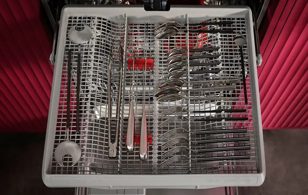 Wysunięta szuflada zmywarki wraz ze sztućami