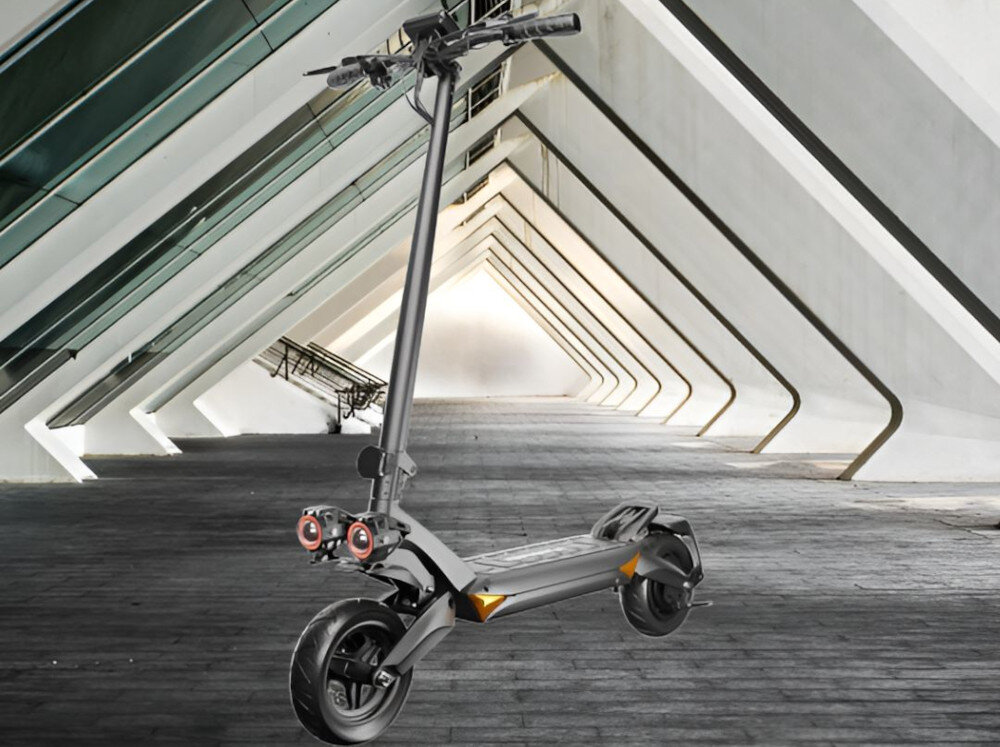 Czarna hulajnoga elektryczna z dużymi kołami i dwoma amortyzatorami stoi na tle nowoczesnej architektury z białymi, skośnymi filarami. Hulajnoga ma widoczne dwa reflektory z przodu.