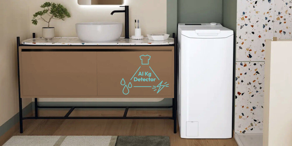W łazience znajduje się biała pralka obok szafki z umywalką. Na szafce widoczny jest napis \'AI Kg Detector\' z ikonami kropli wody i błyskawicy.