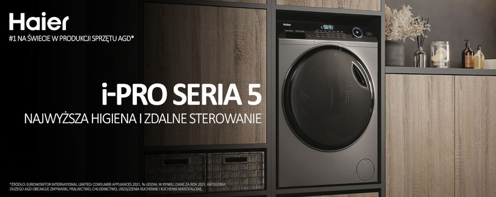 Obraz przedstawia pralko-suszarkę w zabudowie z widocznym logo \'Haier\' oraz napisem \'i-PRO SERIA 5 NAJWYŻSZA HIGIENA I ZDALNE STEROWANIE\'. W tle znajdują się drewniane półki z dekoracjami.