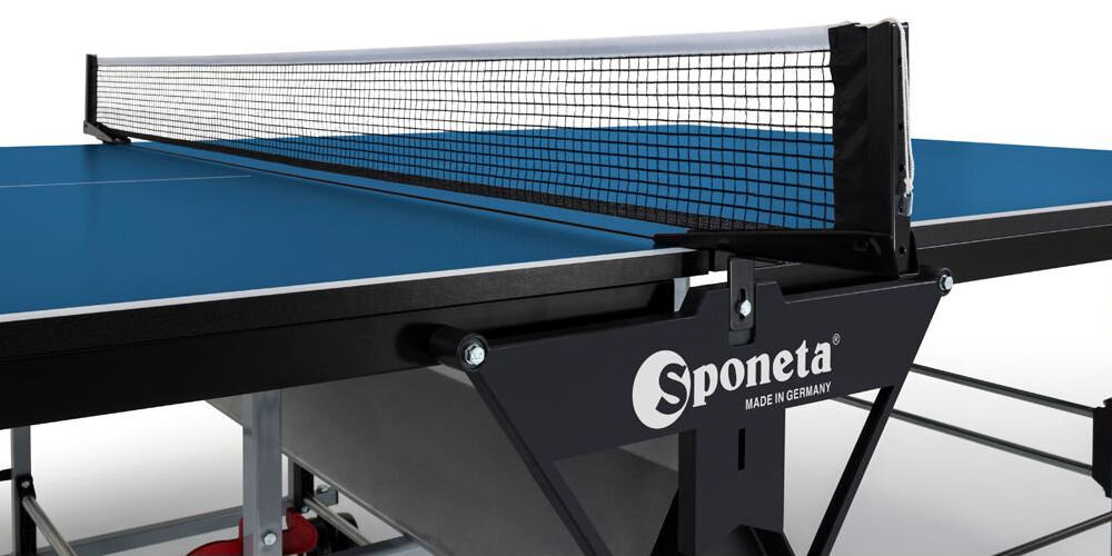 Stół do ping ponga z niebieskim blatem i siatką, z widocznym logo \'Sponeta MADE IN GERMANY\'.