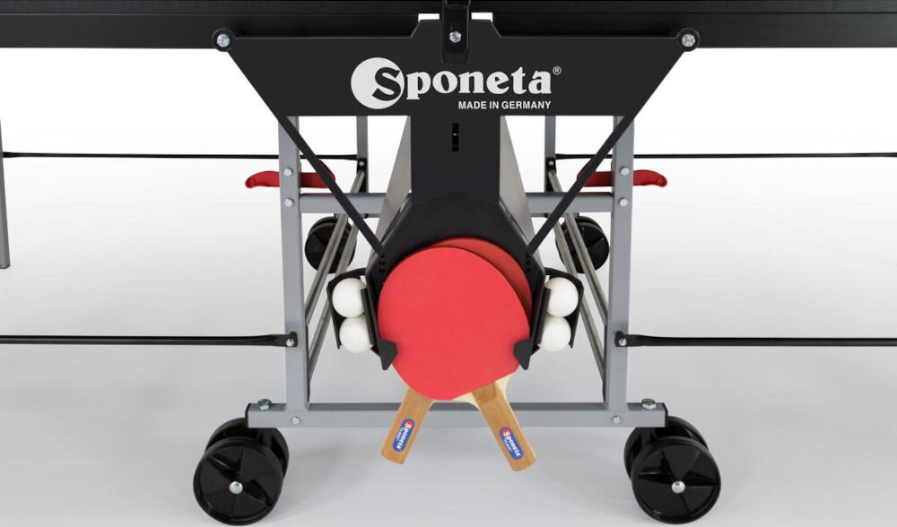 Stół do ping ponga z widocznym logo \'Sponeta Made in Germany\', z miejscem na rakietki i piłeczki. Stół posiada czarne kółka ułatwiające transport.