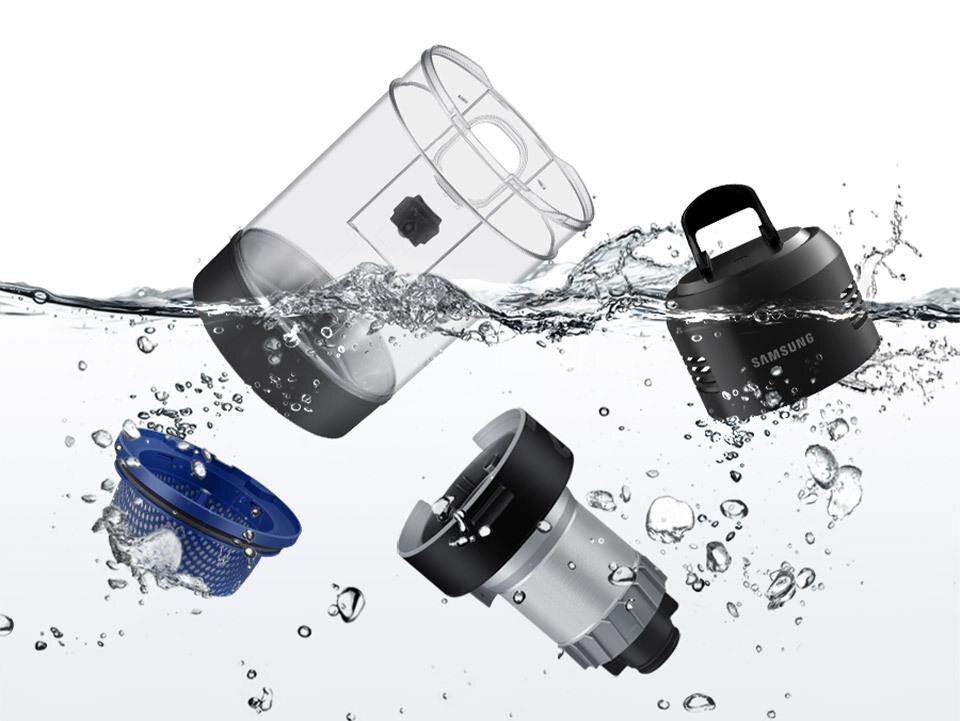 Cztery części odkurzacza unoszą się w wodzie, w tym przezroczysty pojemnik, niebieski filtr, metalowy element oraz czarny element z uchwytem i napisem \'SAMSUNG\'.