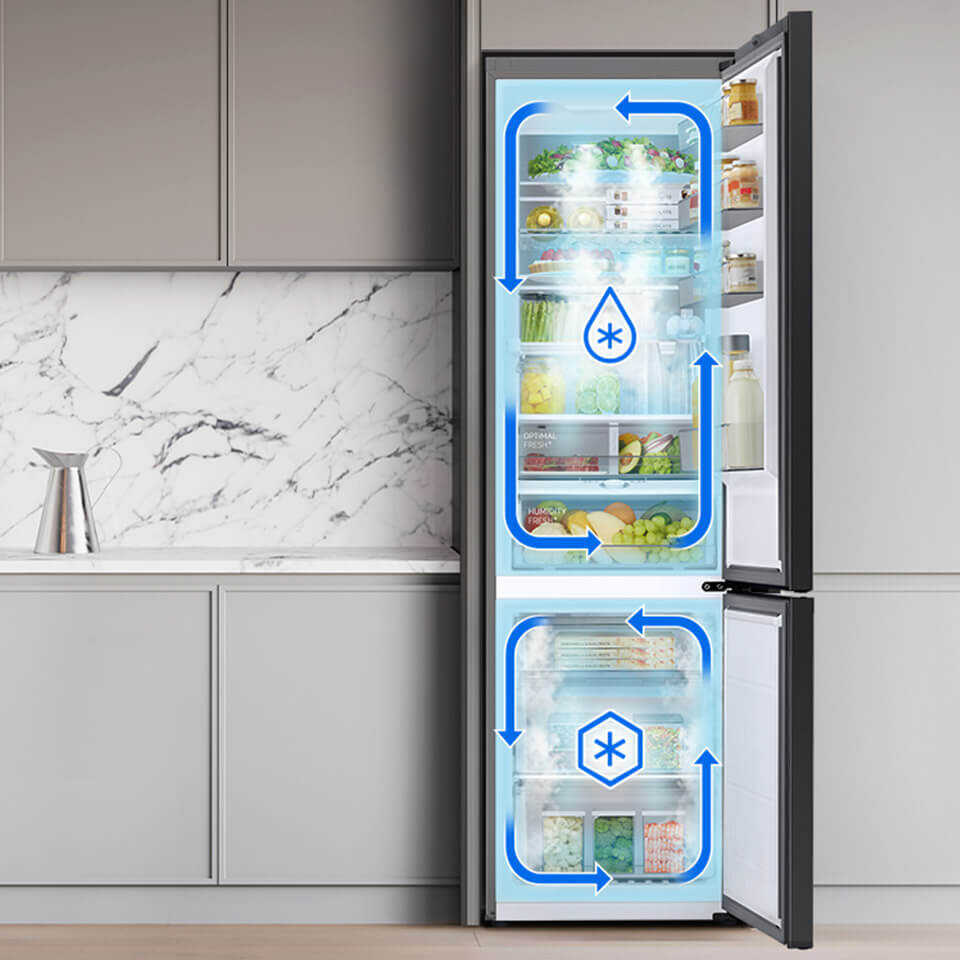 Otwarta lodówka z widocznymi produktami spożywczymi na półkach, z niebieskimi strzałkami wskazującymi przepływ powietrza. Na drzwiach znajdują się butelki i słoiki, a w tle widać kuchenną zabudowę z marmurowym blatem.