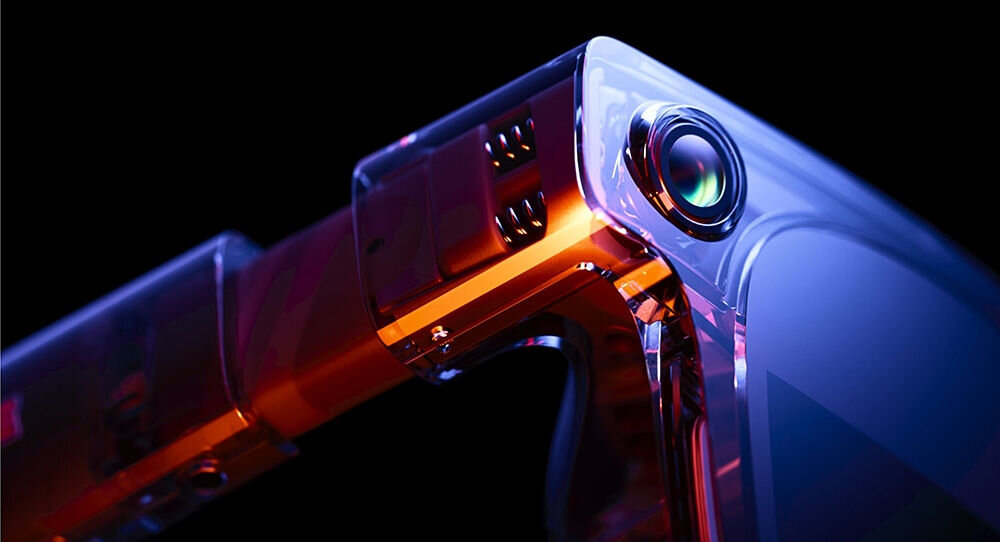 Zbliżenie na nowoczesne okulary z przezroczystymi i kolorowymi elementami, z widocznym obiektywem kamery. Konstrukcja ma futurystyczny wygląd z metalicznymi i szklanymi powierzchniami.