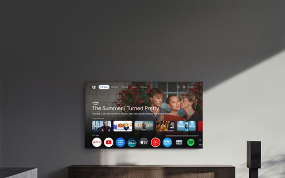 Telewizor XIAOMI S Mini 2026 65 Google TV smart funkcje sterowanie głosowe przesyłanie obrazu łączność porty, telewizor wiszący nad komodą w pomieszczeniu