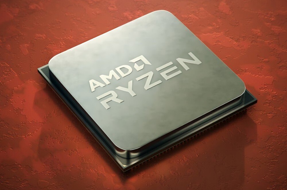 Na obrazie widoczny jest procesor z napisem \'AMD RYZEN\' na metalicznej powierzchni. Tło jest w kolorze czerwonym z teksturą przypominającą powierzchnię ziemi.