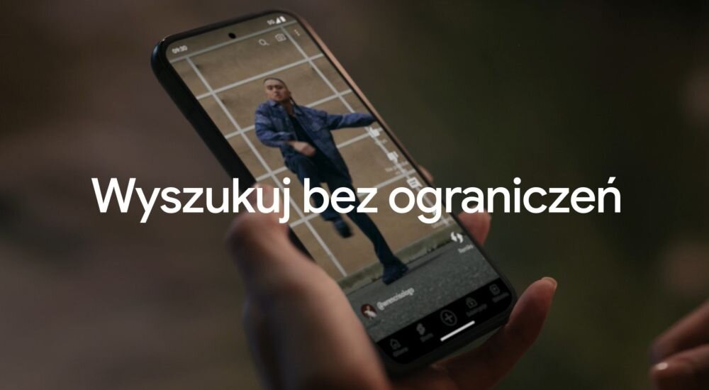 Osoba trzyma smartfon, na ekranie którego widać aplikację z wideo przedstawiającym osobę w ruchu. Na obrazie znajduje się tekst: \'Wyszukuj bez ograniczeń\'.