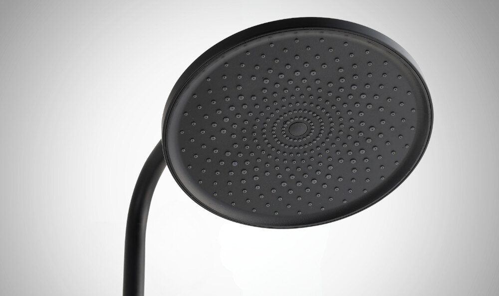 Czarna deszczownica z okrągłą głowicą, posiadająca liczne dysze rozmieszczone równomiernie na powierzchni. Tło jest jednolite i jasne.
