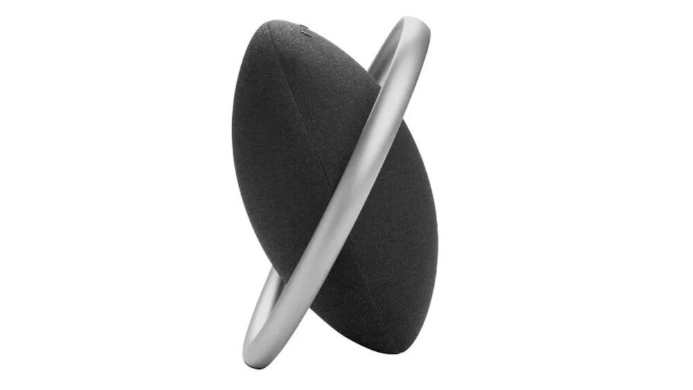 Czarny głośnik mobilny o okrągłym kształcie z metalicznym uchwytem biegnącym przez środek. Powierzchnia głośnika jest gładka i jednolita.