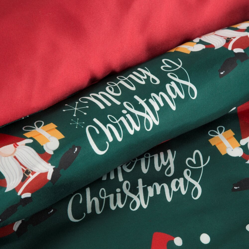 Pościel w kolorze zielonym z napisem \'Merry Christmas\' oraz wzorem przedstawiającym krasnale i prezenty. Widoczny jest także czerwony materiał pościeli.