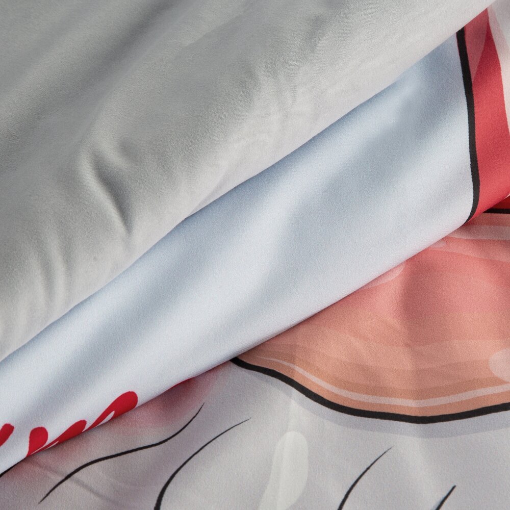 Obraz przedstawia zbliżenie na materiał pościeli z widocznymi kolorami: szarym, białym i różowym oraz fragmentem czerwonego napisu. Wzór zawiera czarne linie i elementy przypominające kształty graficzne.