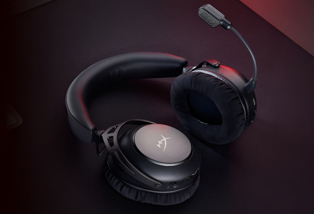 Czarne słuchawki nauszne z mikrofonem, z widocznym logo \'HX\' na nauszniku. Słuchawki leżą na ciemnym tle.