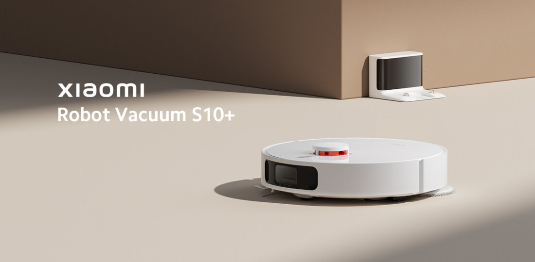 Na obrazie widoczny jest biały robot sprzątający z logo \'xiaomi\' oraz napisem \'Robot Vacuum S10+\'. Robot znajduje się na jasnej powierzchni, a w tle widać stację dokującą przy ścianie.