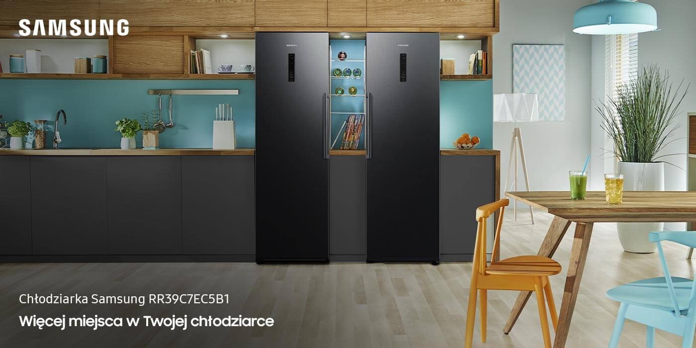 Dwie grafitowe lodówki stoją obok siebie w nowoczesnej kuchni z drewnianymi i szarymi elementami. Na obrazie widoczny jest tekst: \'Chłodziarka Samsung RR39C7EC5B1 Więcej miejsca w Twojej chłodziarce\'.