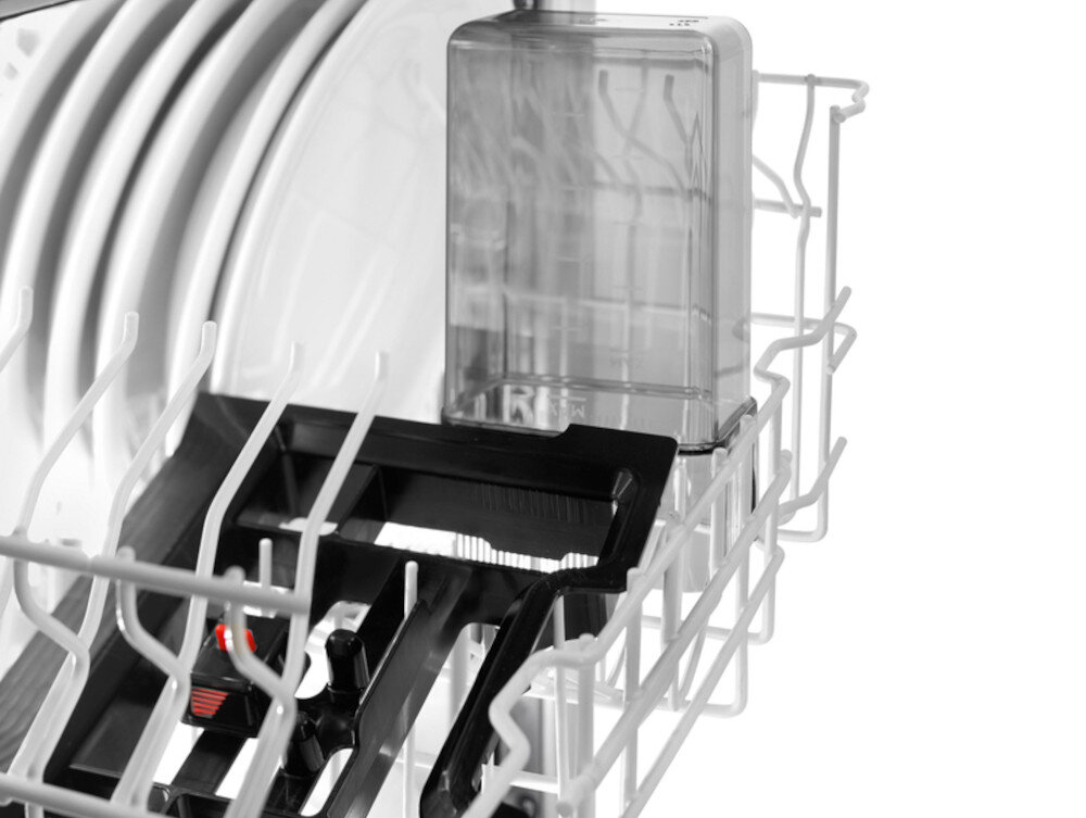 Wnętrze zmywarki z widocznym koszem na naczynia i przezroczystym pojemnikiem. W tle znajdują się białe pręty kosza.