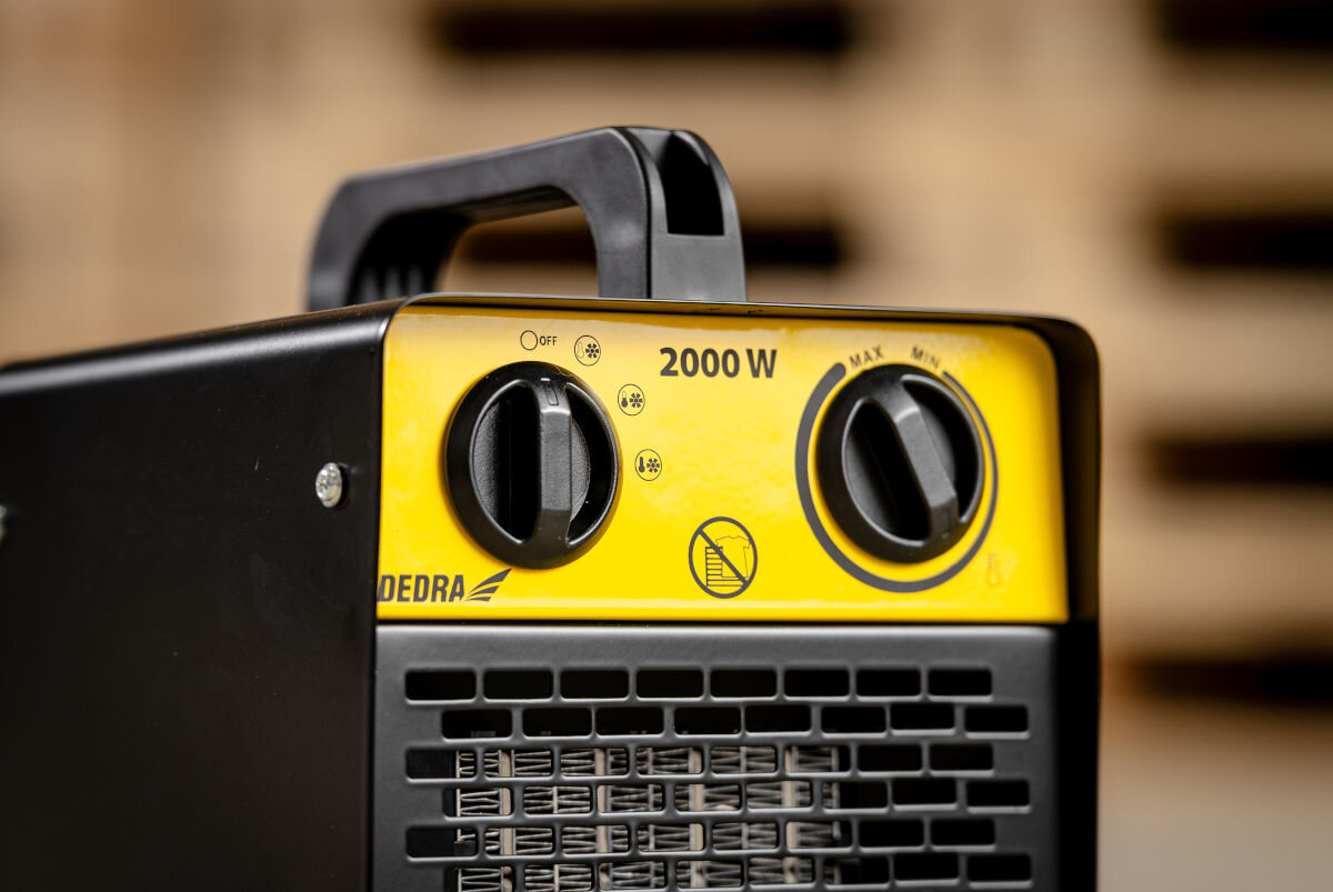 Nagrzewnica elektryczna z żółtym panelem sterowania, na którym znajdują się dwa pokrętła i napis \'2000 W\'. Widoczne jest logo \'DEDRA\' oraz symbol zakazu umieszczania na schodach.