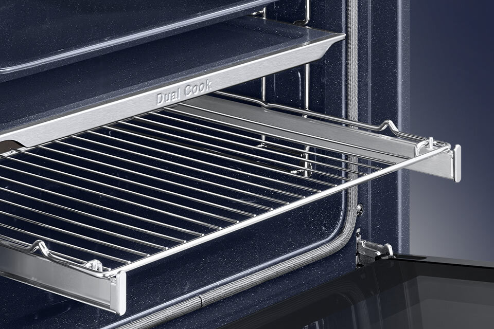 Wnętrze piekarnika z wysuniętą metalową kratką. Na krawędzi widoczny napis \'Dual Cook\'.