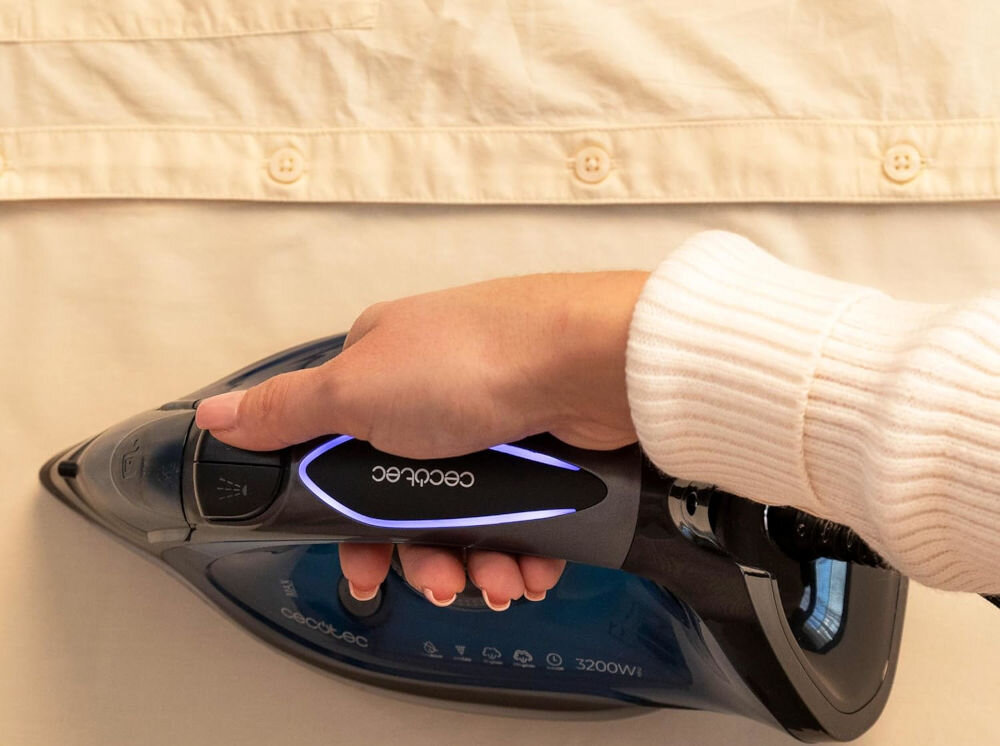 Żelazko CECOTEC IronHero 3200 Force Anodized osoba naciska przycisk na żelazku prasowanie koszuli podświetlenie w walce z trudnymi zagnieceniami intensywny wyrzut pary na poziomie 270 g/min Para głęboko przenika nawet trudne do wygładzenia miejsca optymalny wygląd dla wymagających użytkowników