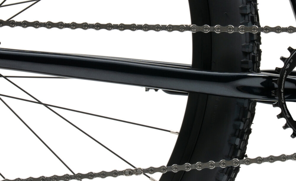 RRower górski MTB INDIANA X-Pulser 2.9 M17 29 cali męski Czarno-biały zbliżenie na łańcuch i napęd białe tło łańcuch SHIMANO typu KCNLG500116Q dopasowany do napędów 9-rzędowych odpowiednia konstrukcja ogniw wspiera płynną współpracę z elementami układu napędowego zmiana przełożeń może odbywać się sprawnie i z zachowaniem odpowiedniej kultury pracy