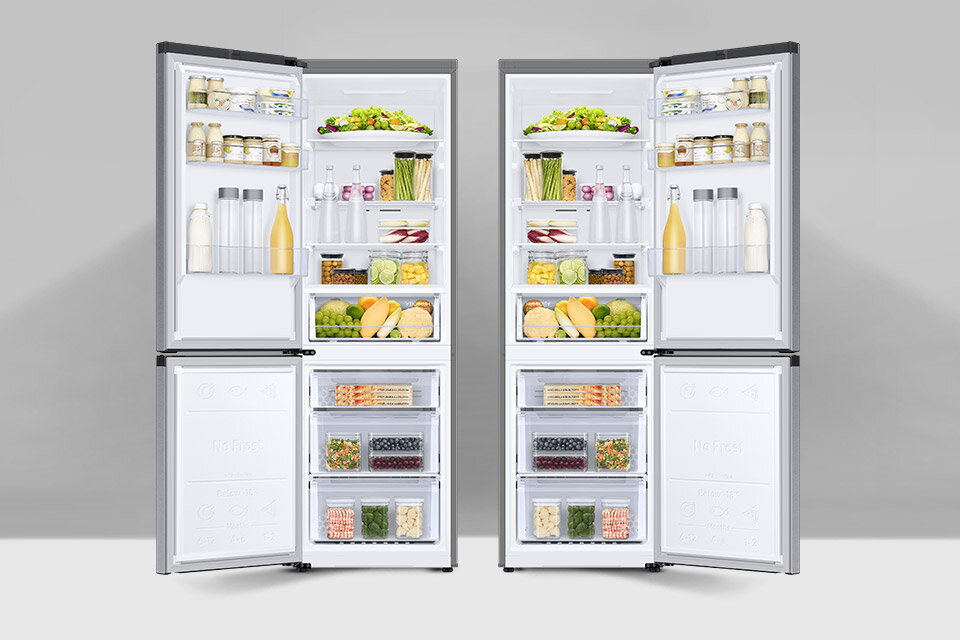 Dwie otwarte lodówki wypełnione różnorodnymi produktami spożywczymi, takimi jak butelki, słoiki, warzywa i owoce. Na drzwiach zamrażarek widoczny jest napis \'No Frost\'.