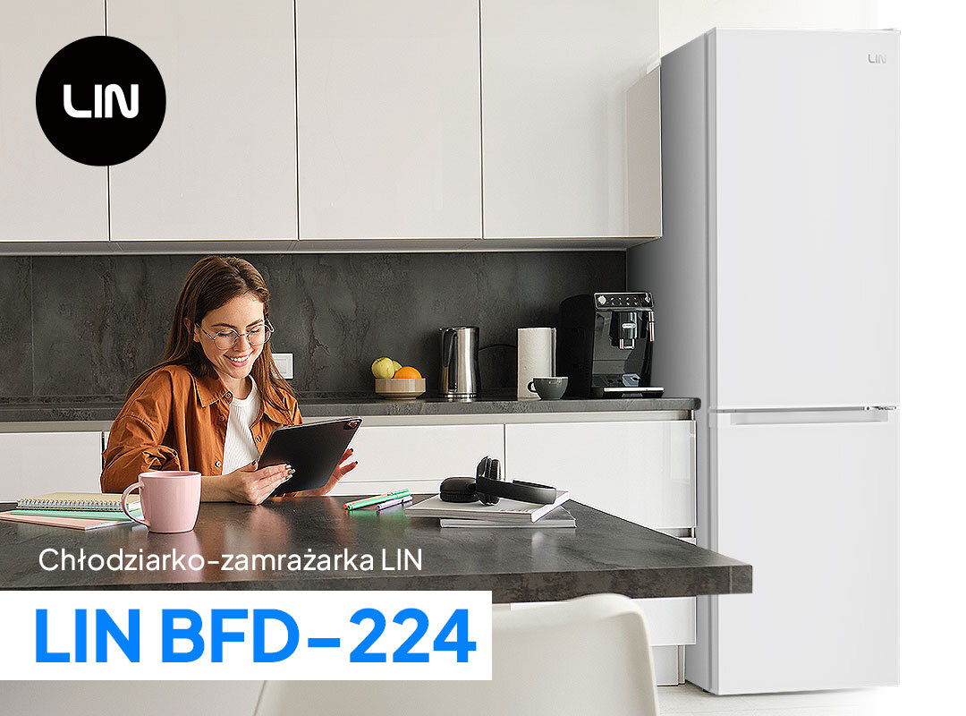 Kuchnia z białą lodówką LIN LI-BFD224 o wysokości 170 cm. Na blacie znajduje się ekspres do kawy, czajnik i miska z owocami, a na pierwszym planie osoba korzysta z tabletu.