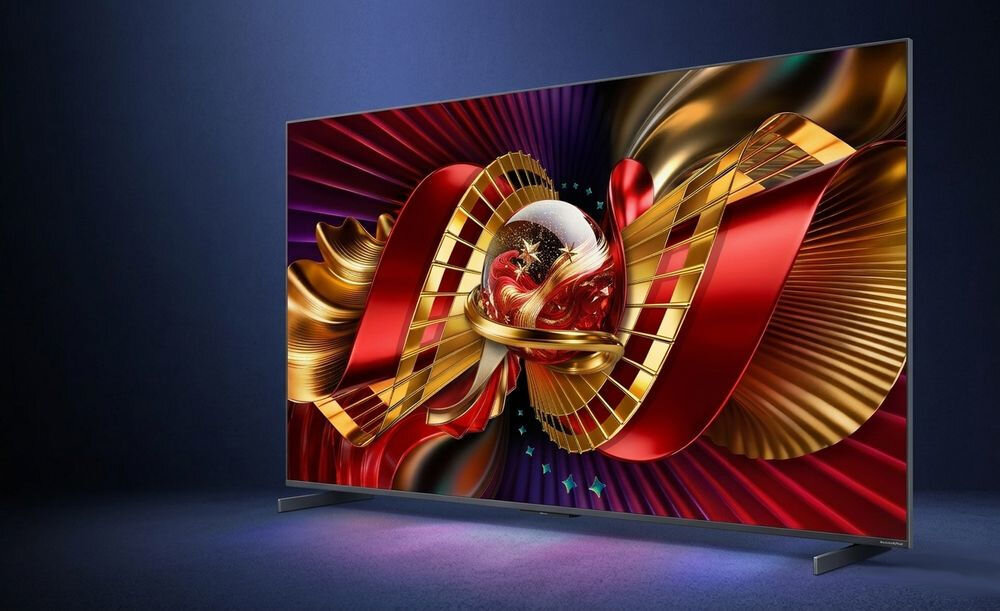 Telewizor z dużym ekranem wyświetla kolorową grafikę z abstrakcyjnymi kształtami w odcieniach czerwieni, złota i fioletu. Obraz jest dynamiczny i pełen detali, co podkreśla jakość wyświetlacza.