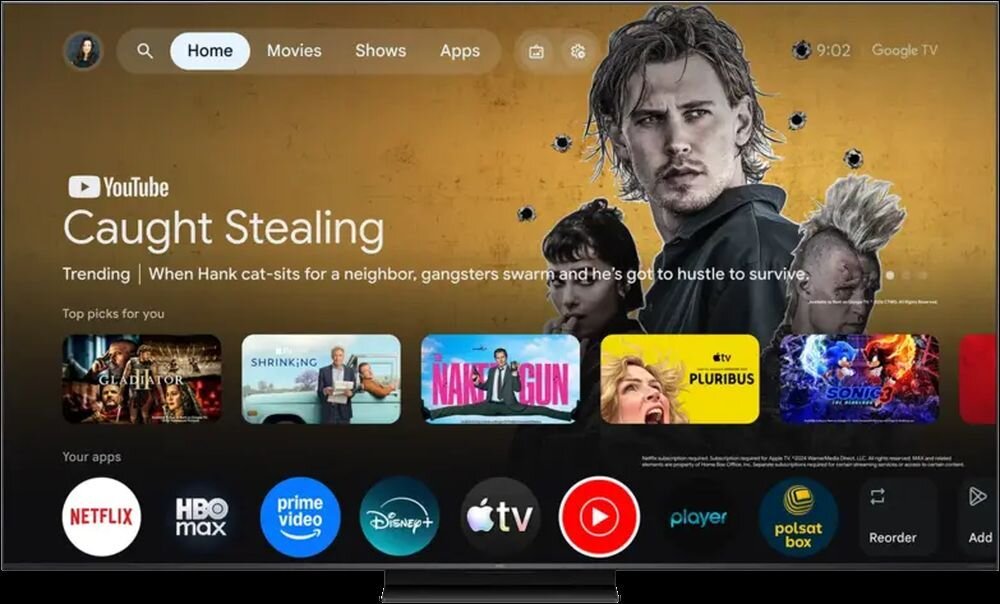 Ekran telewizora wyświetla interfejs Google TV z aplikacjami takimi jak Netflix, HBO Max, Prime Video, Disney+, Apple TV, Player i Polsat Box. Na ekranie widoczny jest także film \'Caught Stealing\' oraz różne rekomendacje filmowe.