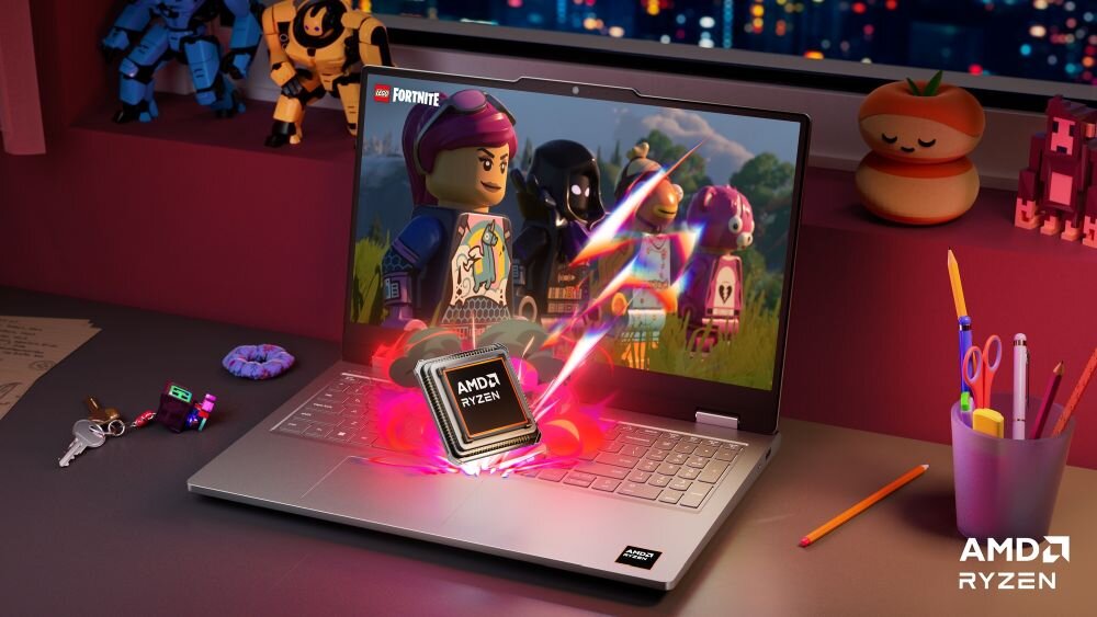 Na biurku znajduje się otwarty laptop z wyświetlonym na ekranie obrazem z gry LEGO Fortnite. Na klawiaturze widoczny jest procesor z napisem \'AMD RYZEN\', a w prawym dolnym rogu ekranu znajduje się logo \'AMD RYZEN\'.