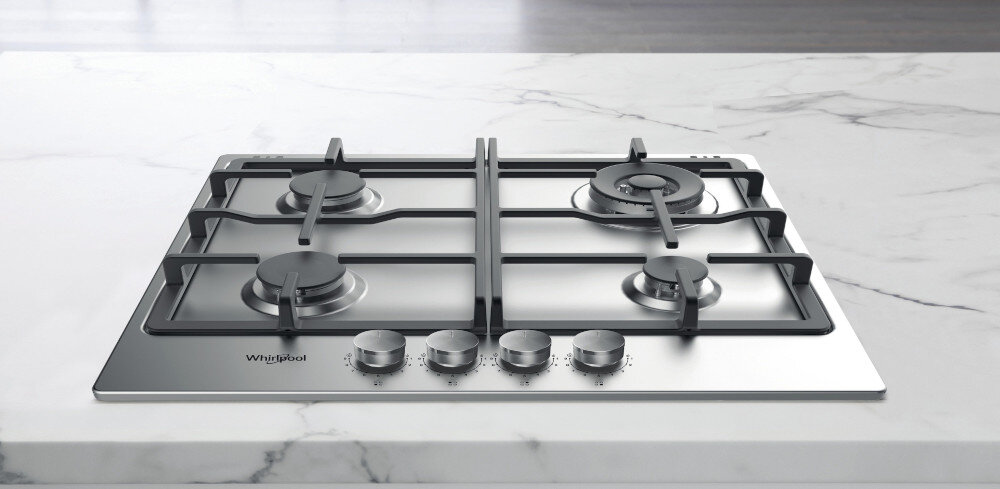 Na obrazie widoczna jest płyta gazowa z czterema palnikami i metalowymi pokrętłami. Na powierzchni płyty znajduje się logo \'Whirlpool\'.