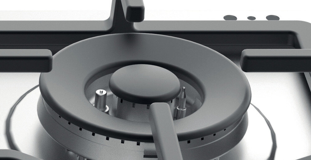 Zbliżenie na palnik płyty gazowej z czarnym rusztem i metalowymi elementami. W tle widoczne są dwa okrągłe przyciski na panelu sterowania.