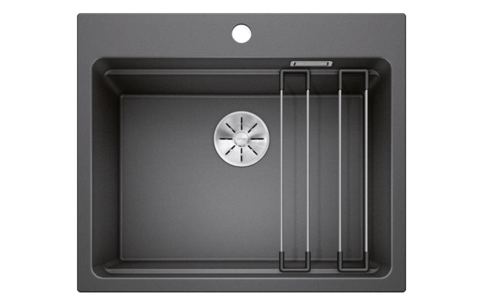 Czarny zlewozmywak jednokomorowy z okrągłym odpływem i dwoma metalowymi relingami. Na górze widoczny jest otwór na baterię.