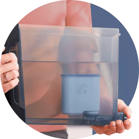 Osoba trzyma przezroczysty pojemnik z filtrem wody, na którym widnieje napis \'Aqua Clean\'.