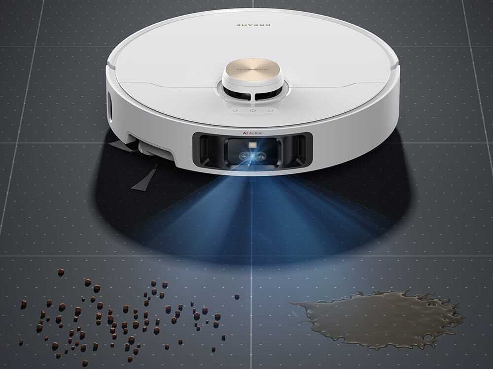 Na obrazie widoczny jest biały robot sprzątający z logo \'DREAME\' na górze. Robot emituje niebieskie światło na podłogę, na której znajdują się rozsypane drobinki i plama cieczy.