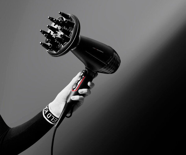 Czarna suszarka do włosów z dyfuzorem, trzymana w dłoni. Na suszarce widoczny jest napis \'ROWENTA x KARL LAGERFELD\'.