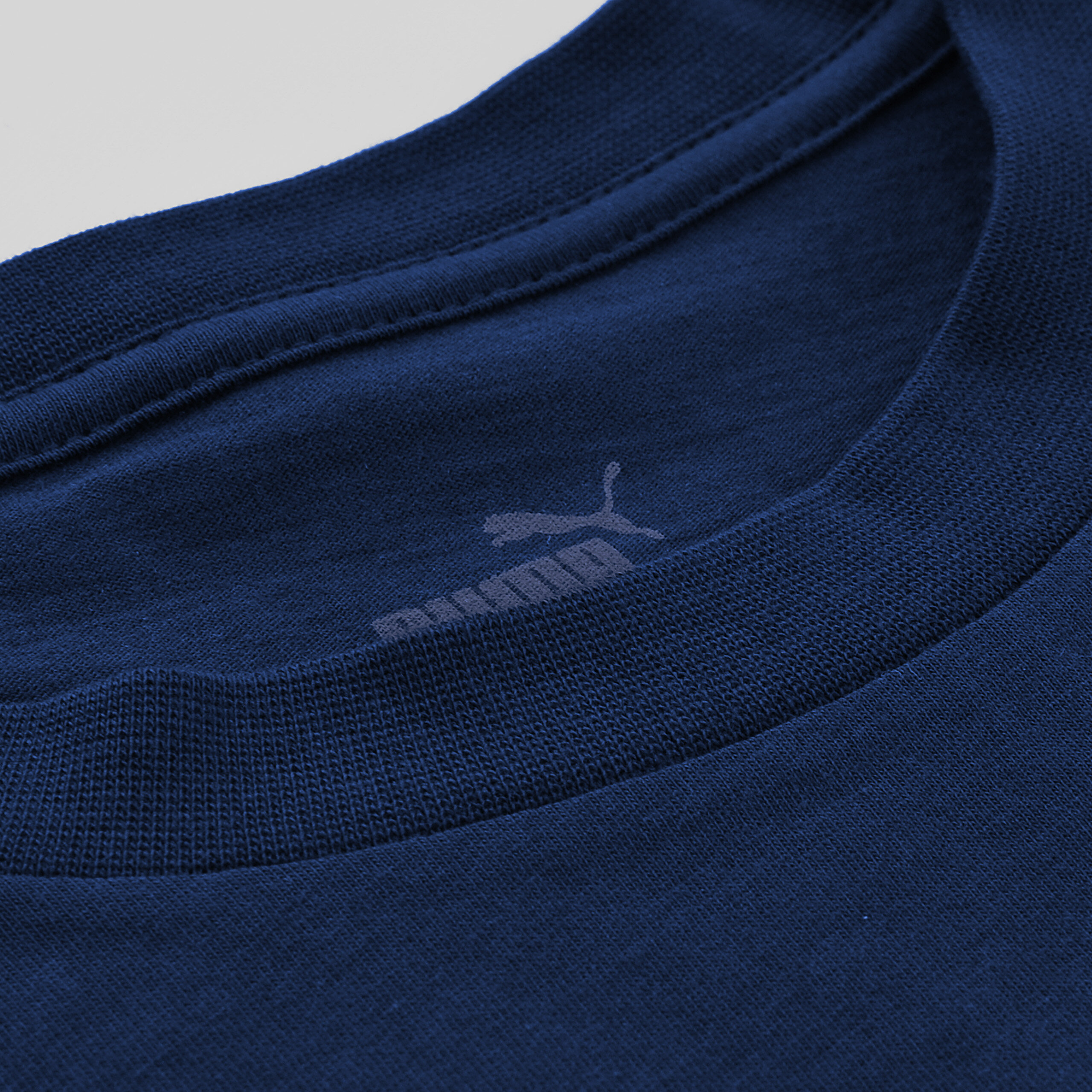 Granatowa koszulka z widocznym logo Puma na wewnętrznej stronie kołnierza.