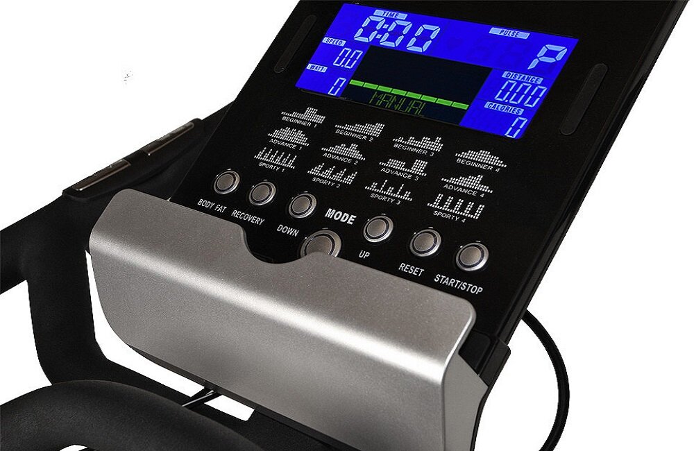 Panel sterowania roweru spinningowego z wyświetlaczem LCD pokazującym różne parametry, takie jak czas, dystans i kalorie. Widoczne są przyciski funkcyjne, w tym \'MODE\', \'UP\', \'RESET\' i \'START/STOP\'.
