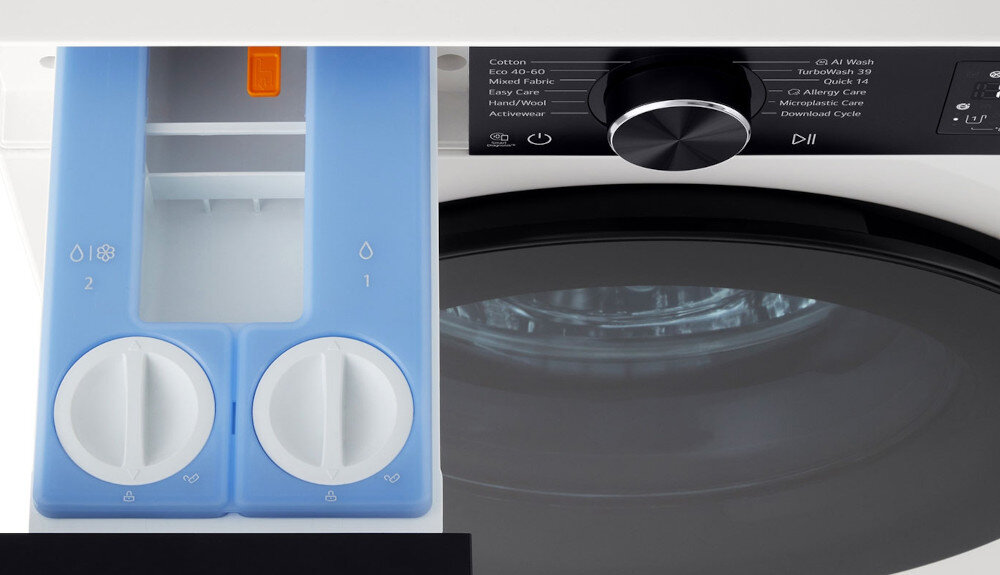 PRALKA LG F4X5509THB Zbliżenie na szufladę dozownika pralki LG z niebieskim panelem podzielonym na dwie sekcje oznaczone ikonami kropli i pokrętłami regulacji. Obok widoczny jest fragment panelu sterowania z pokrętłem wyboru programu, co podkreśla wygodną, precyzyjną regulację ilości detergentu i płynu zmiękczającego