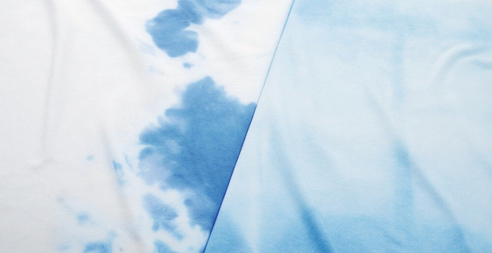 Obraz przedstawia dwa kawałki materiału w odcieniach niebieskiego. Jeden z nich ma nieregularne, ciemniejsze plamy, a drugi jest jednolicie jasnoniebieski.