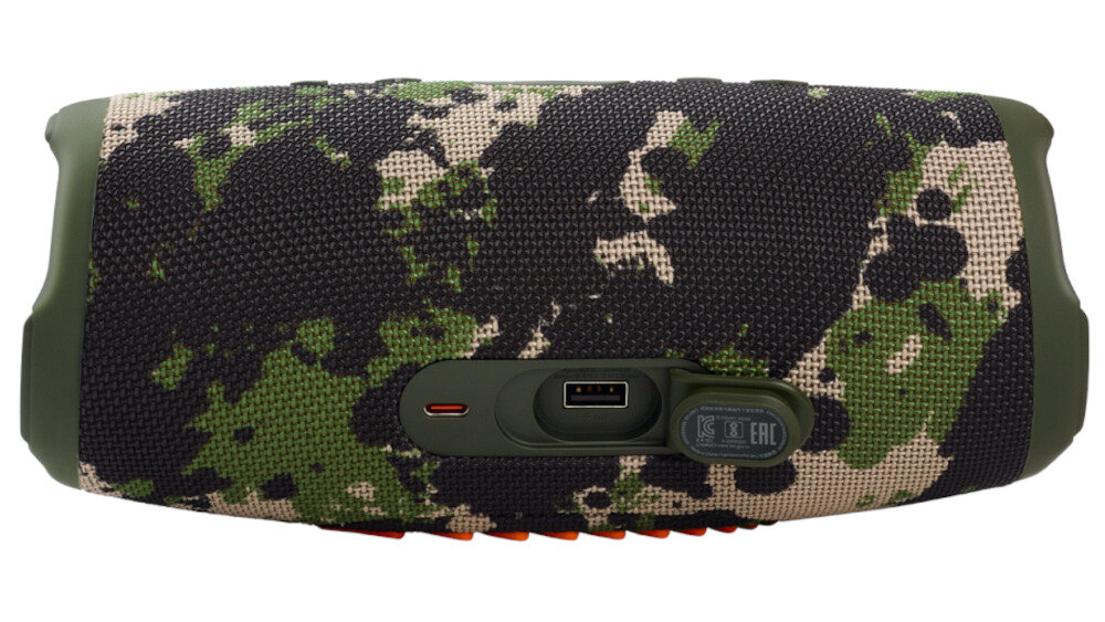 Głośnik mobilny z kamuflażowym wzorem, posiada port USB i port ładowania. Obok portów znajdują się symbole certyfikacji CE i EAC.